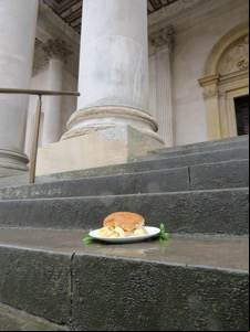Brown Quavers roll on wet steps in front of a column