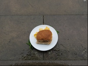 Brown roll fills with Quavers on wet pavement