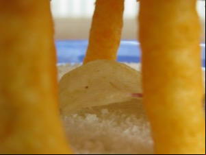 Close up of potato crisp among Wotsits and bread