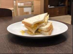 Potato crisps in sliced white bread with bite taken