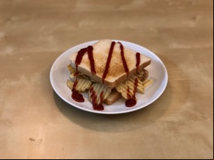 Crinkle-cut crisps in white toast with drizzle