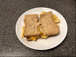 Crinkle-cut crisps in brown bread nearly torn in half