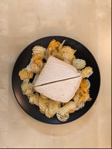Overhead view of crisps surrounding a sandwich