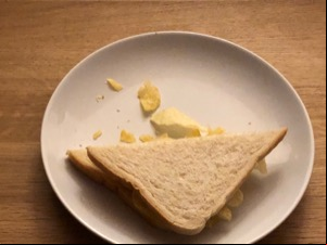 Half of a diagonally-cut white crisp sandwich