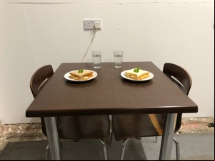 Dining table with two crisp sandwiches laid out