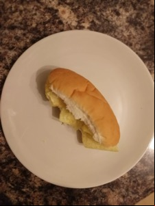 Overhead view of white finger roll containing crisps