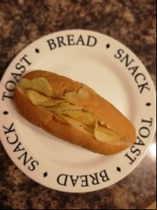 Overhead view of crisp-filled split finger roll on a plate