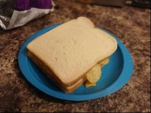 Crisp-filled white sandwich on a plastic plate