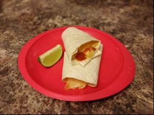 Wrap containing crisps and sauce alongside lime