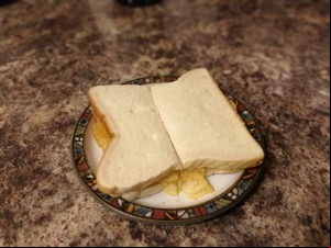 Halved white crisp sandwich on a plate on granite