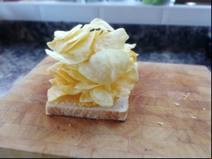 Lots of crisps piled onto white bread