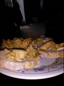 Flash photo of corn snacks and brie on sliced bread