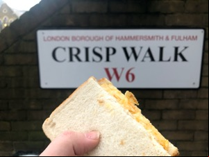 Half of a crisp sandwich held up to Crisp Walk sign