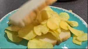 Lid dropped onto white crisp sandwich in slow motion